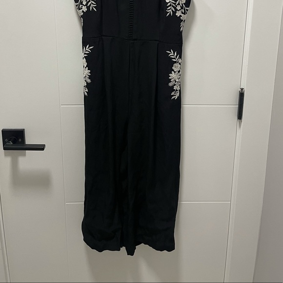 Black romper with white floral detailing. - Picture 3 of 3